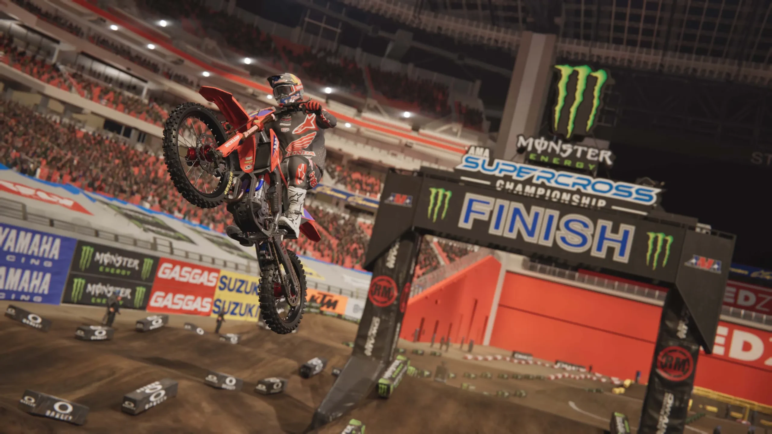 Captura Monster Energy Supercross 6 – Motociclista Realiza Maniobra Aerea Al Cruzar El Arco De Meta Dentro De Un Estadio Iluminado Scaled