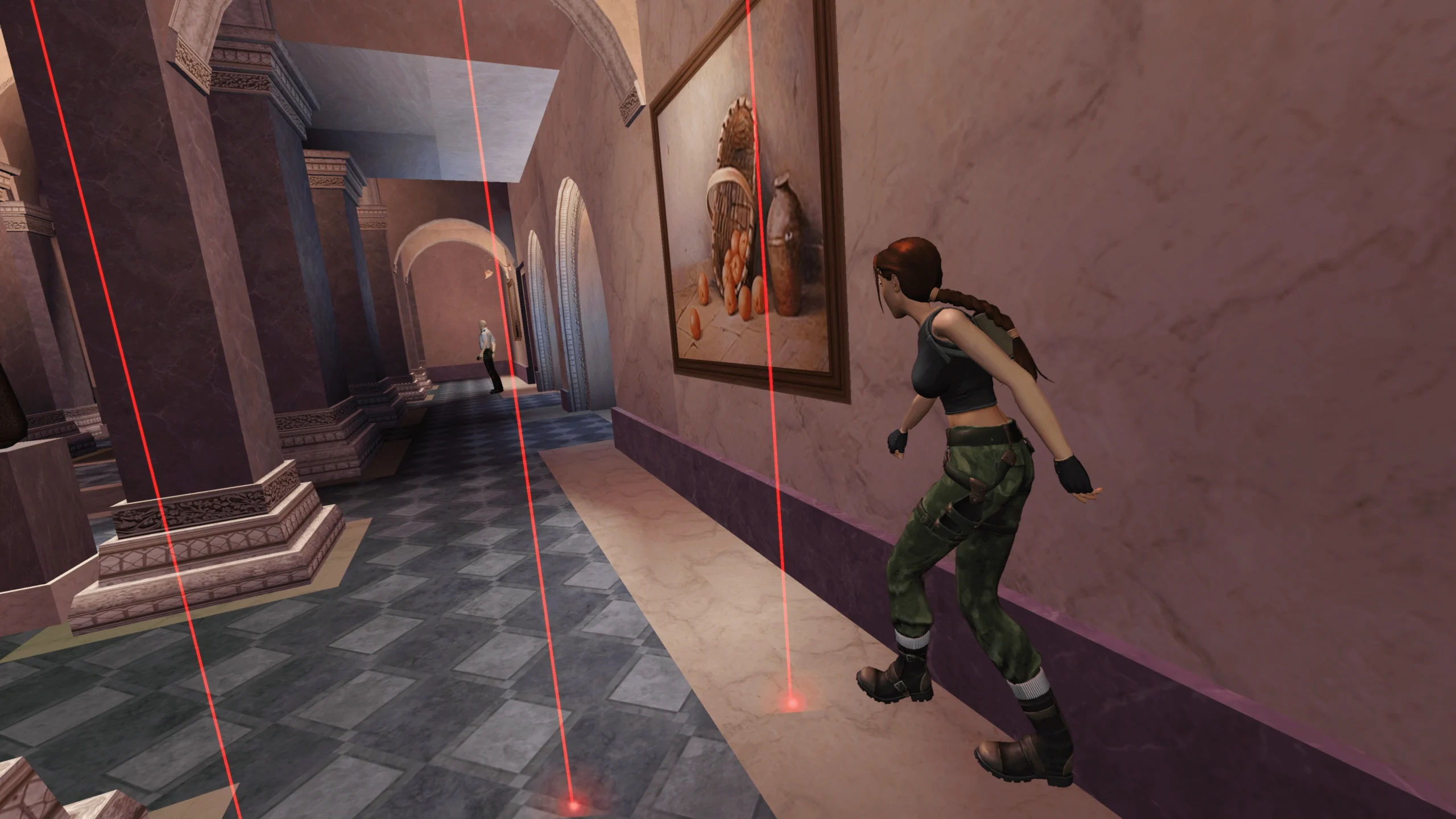 Captura Sigilo En El Louvre – Lara Se Agazapa En Un Pasillo Del Museo Sorteando Finos Rayos Laser Rojos Con Un Guardia Al Fondo Scaled