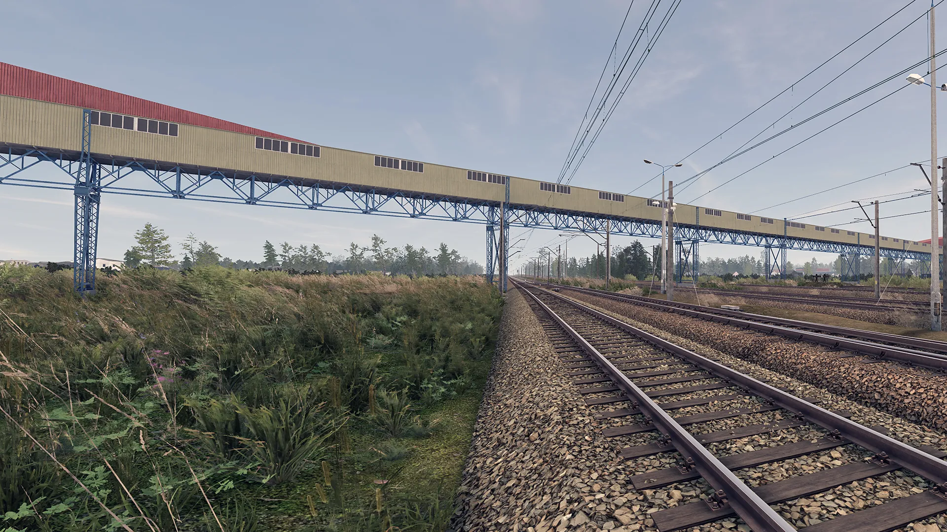 Captura SimRail The Railway Simulator – Vias Ferreas Extensas Bajo Un Puente Rojo En Zona Rural