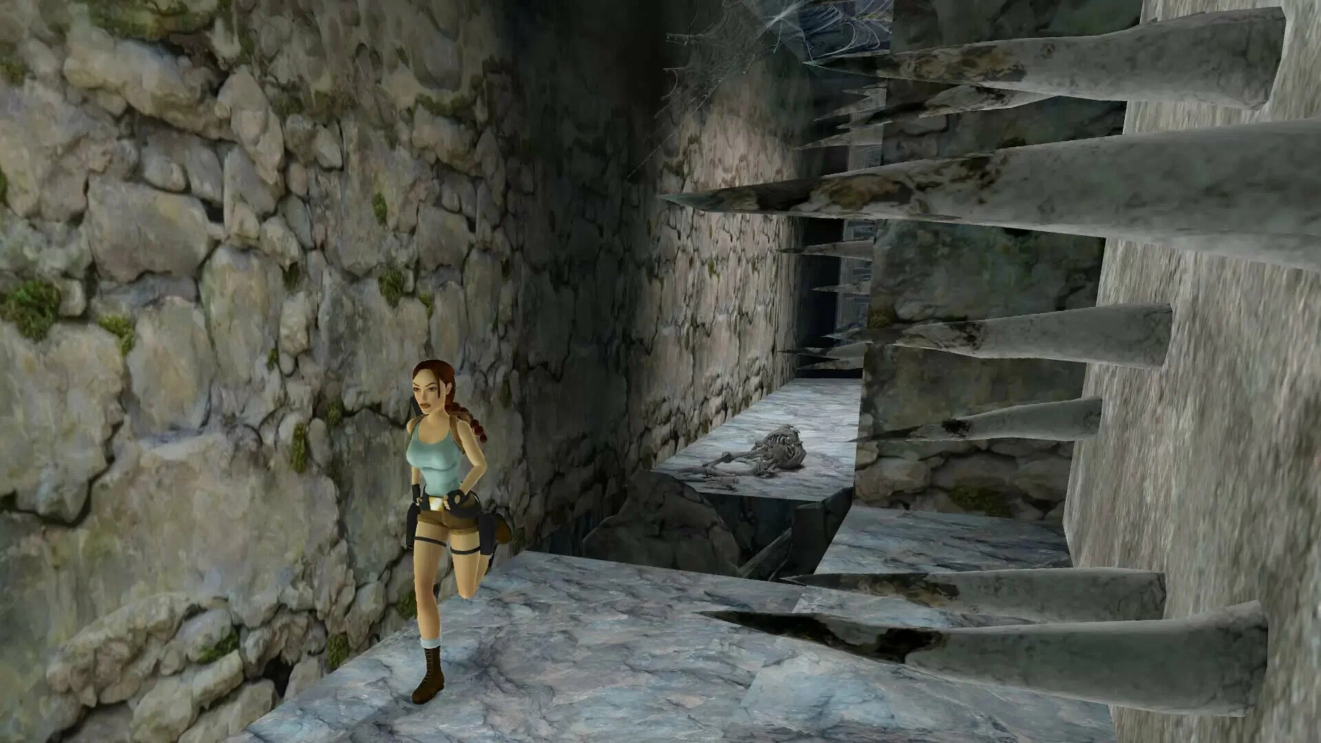 Captura Tomb Raider I–II–III Remastered – Lara Corre Por Un Pasillo Rocoso Con Trampas De Estacas Y Un Esqueleto En El Suelo
