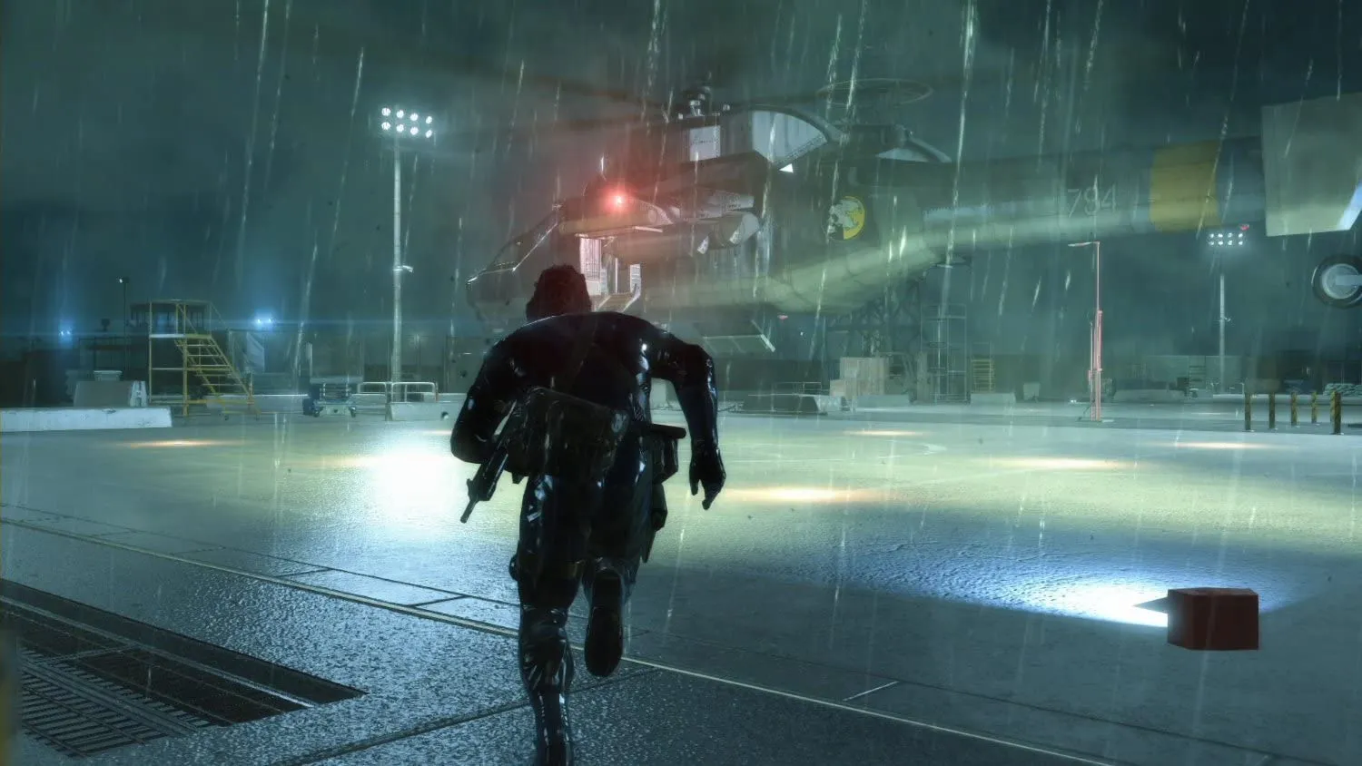 Captura Metal Gear Solid V Ground Zeroes Un Helicoptero Aterriza Mientras El Personaje Corre Hacia El Bajo La Lluvia